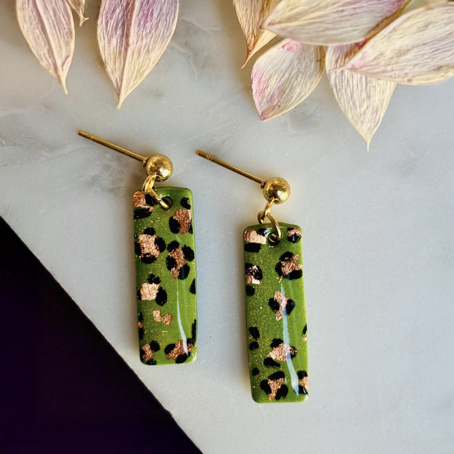 Elegant leopard print drop earrings with gold foil accents, hand-painted and handmade with polymer clay.
