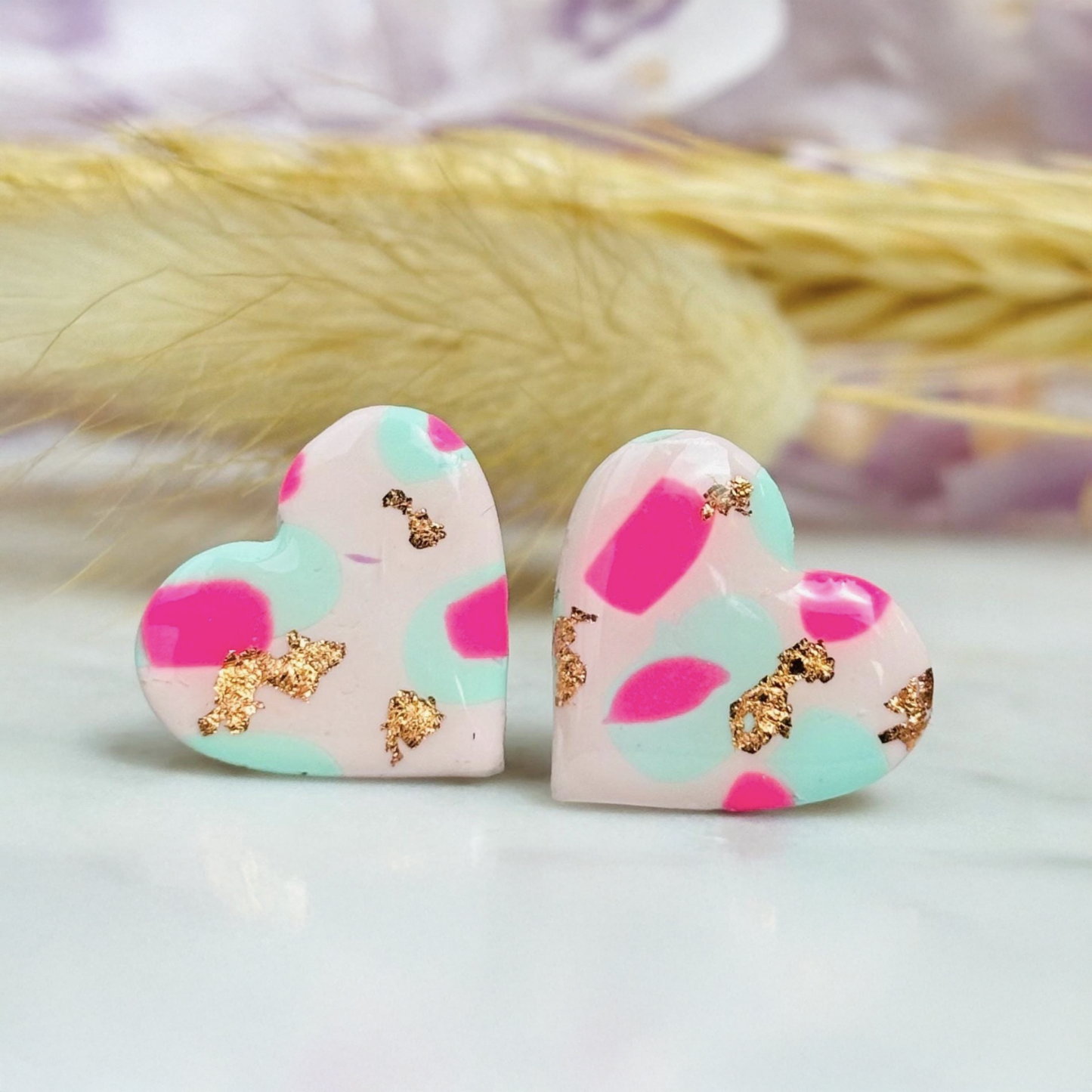 Pastel pink heart stud earrings with a spring blossom design, featuring pinks, mint green, and rose gold foil.