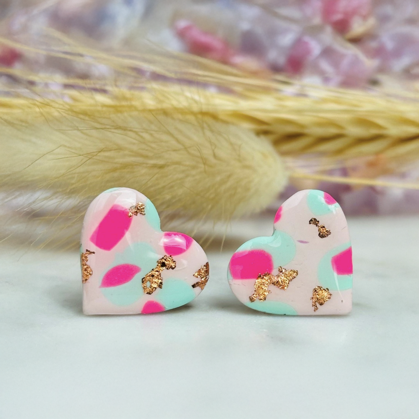 Pastel pink heart stud earrings with a spring blossom design, featuring pinks, mint green, and rose gold foil.