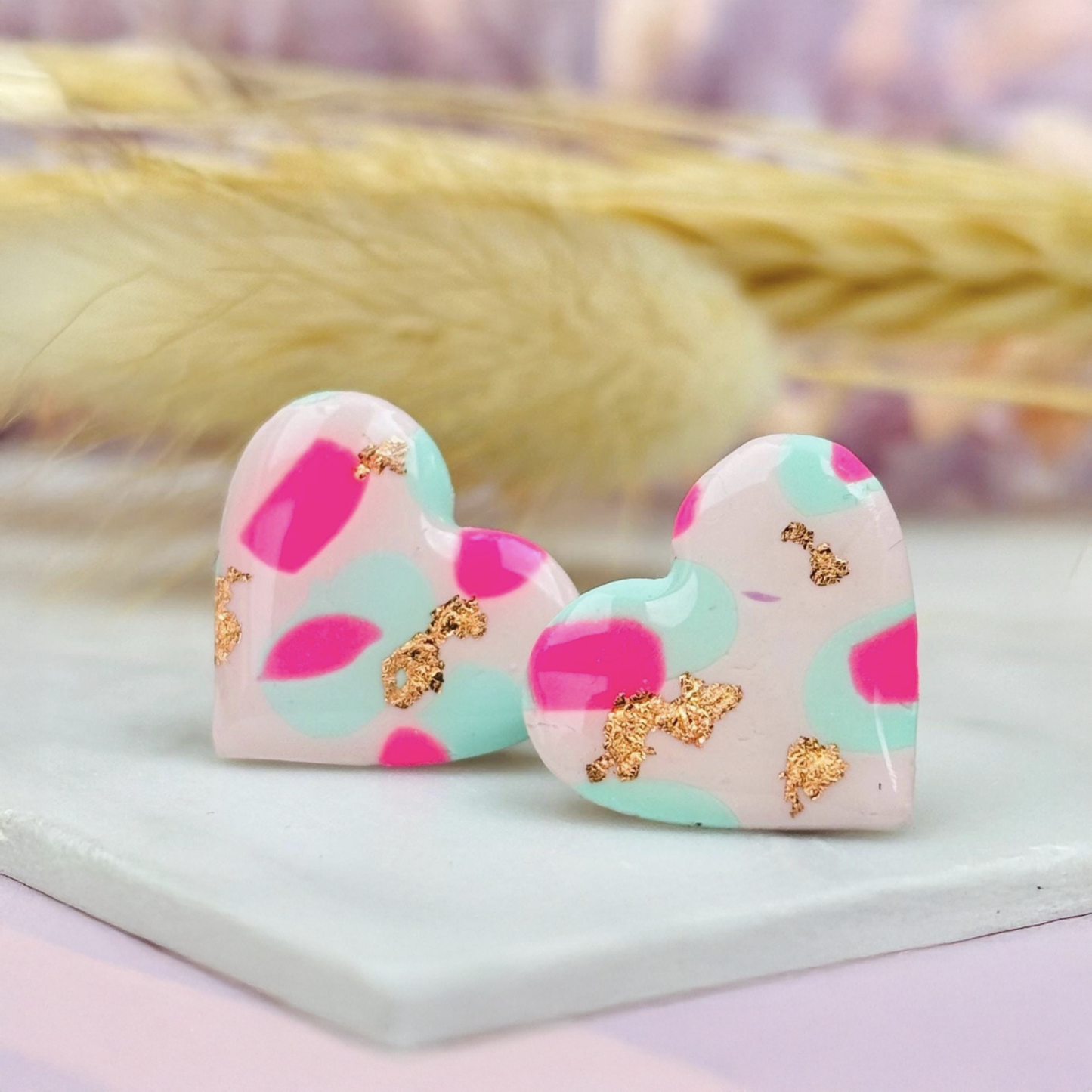Pastel pink heart stud earrings with a spring blossom design, featuring pinks, mint green, and rose gold foil.