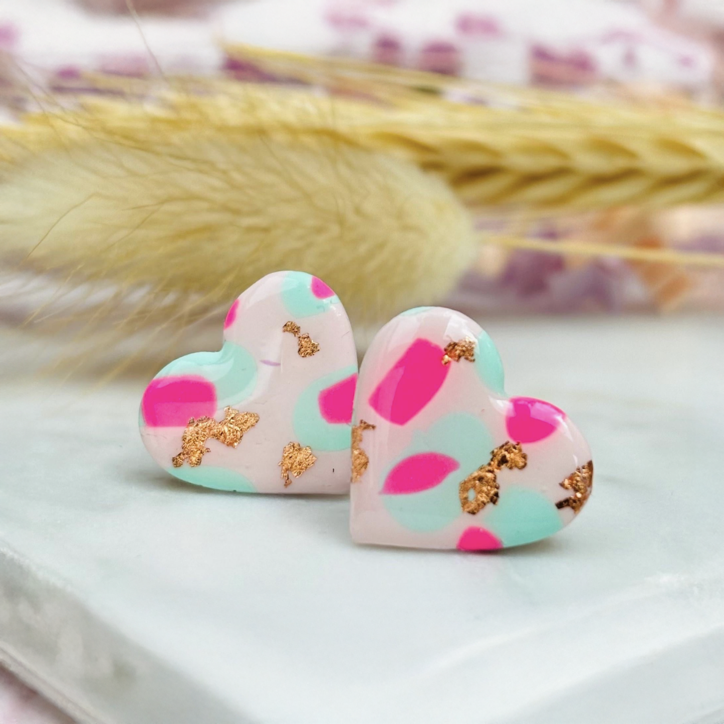 Pastel pink heart stud earrings with a spring blossom design, featuring pinks, mint green, and rose gold foil.