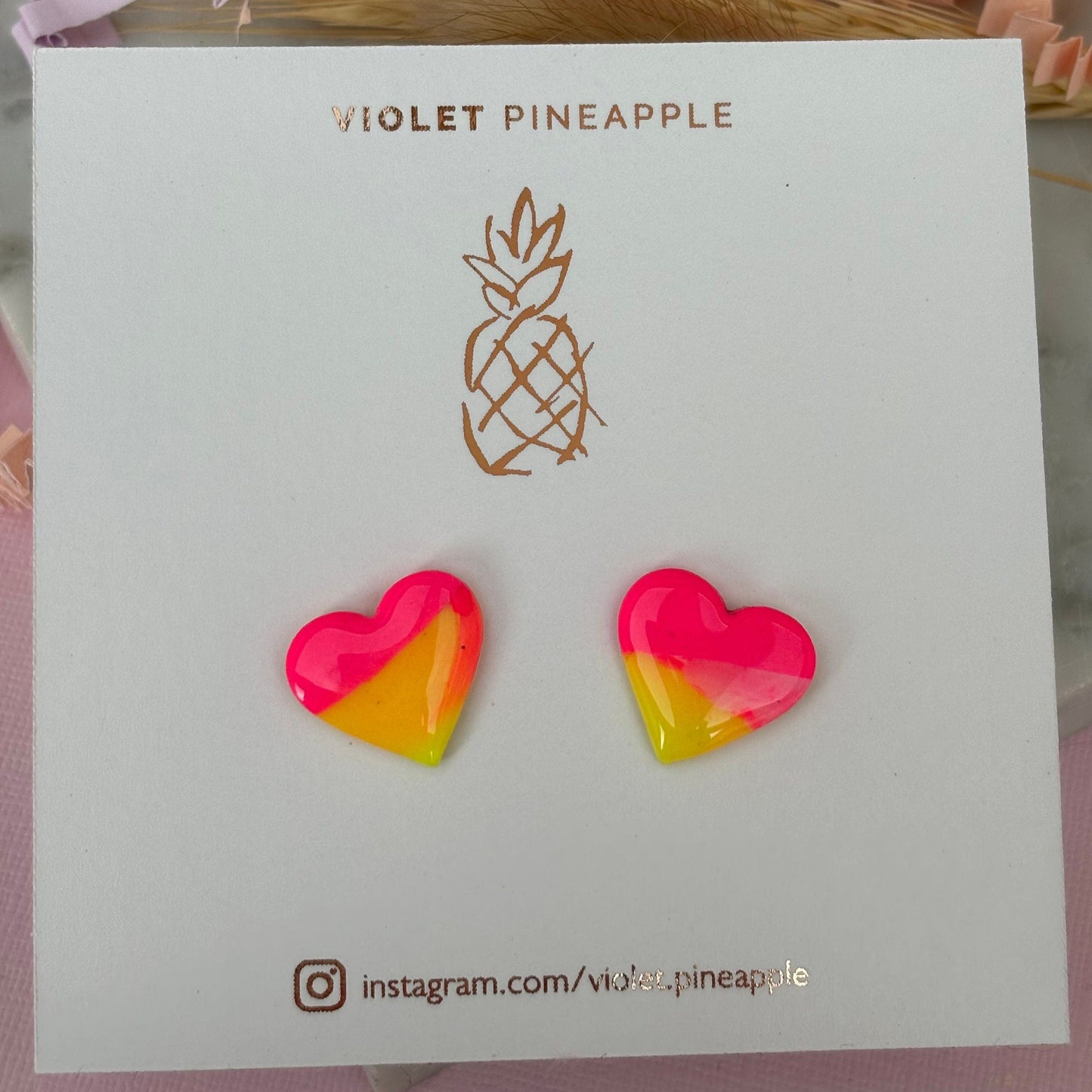 Vibrant 80s-inspired heart-shaped stud earrings, handmade with polymer clay. Features a sunset-inspired color palette of yellow and pink.
