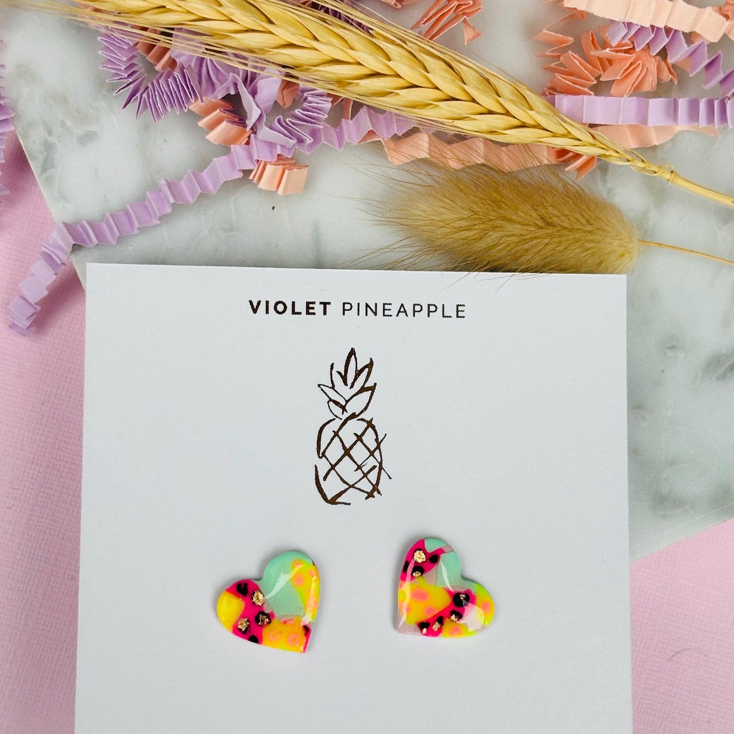 Chic heart-shaped stud earrings with a hand painted leopard print, handmade with polymer clay.