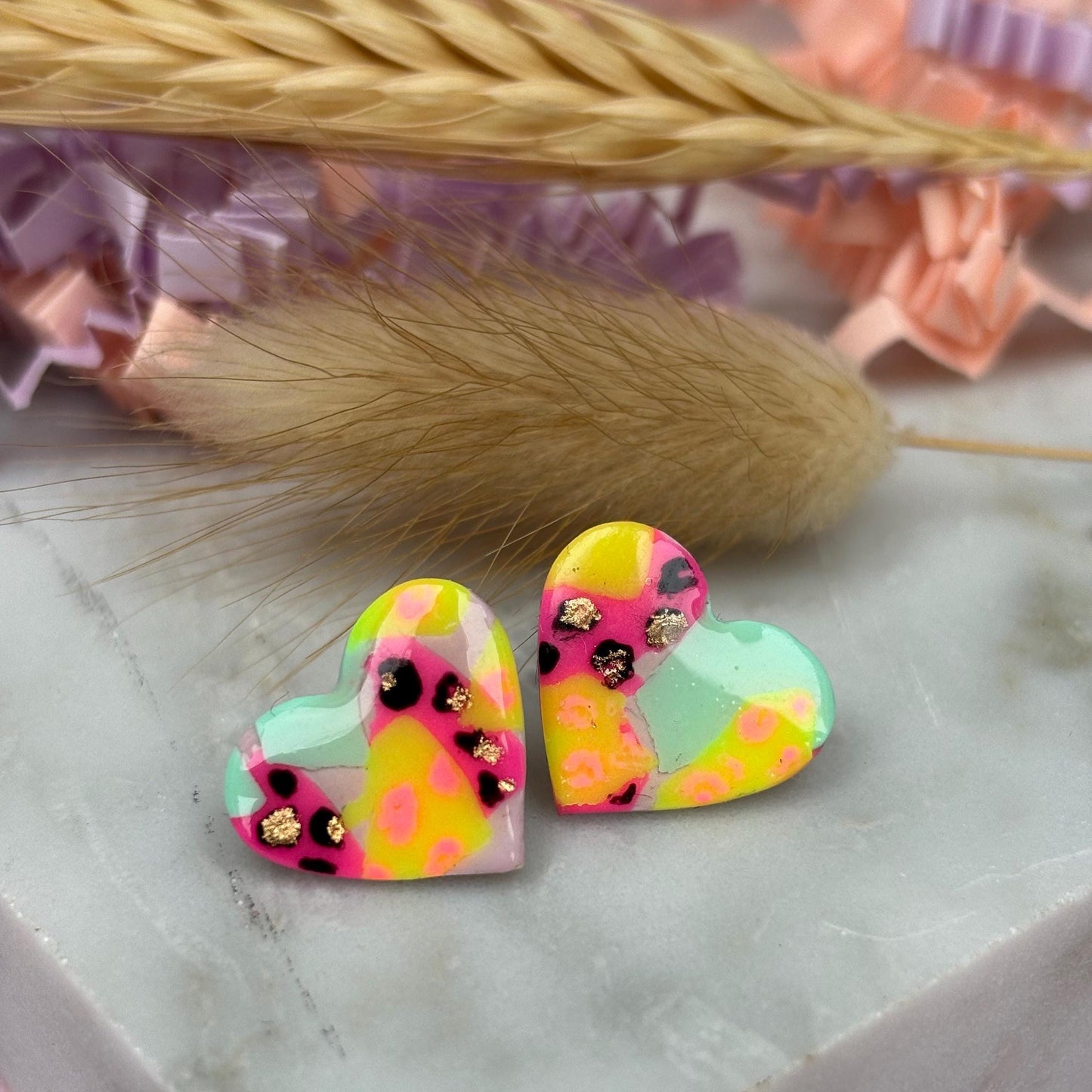 Chic heart-shaped stud earrings with a hand painted leopard print, handmade with polymer clay.