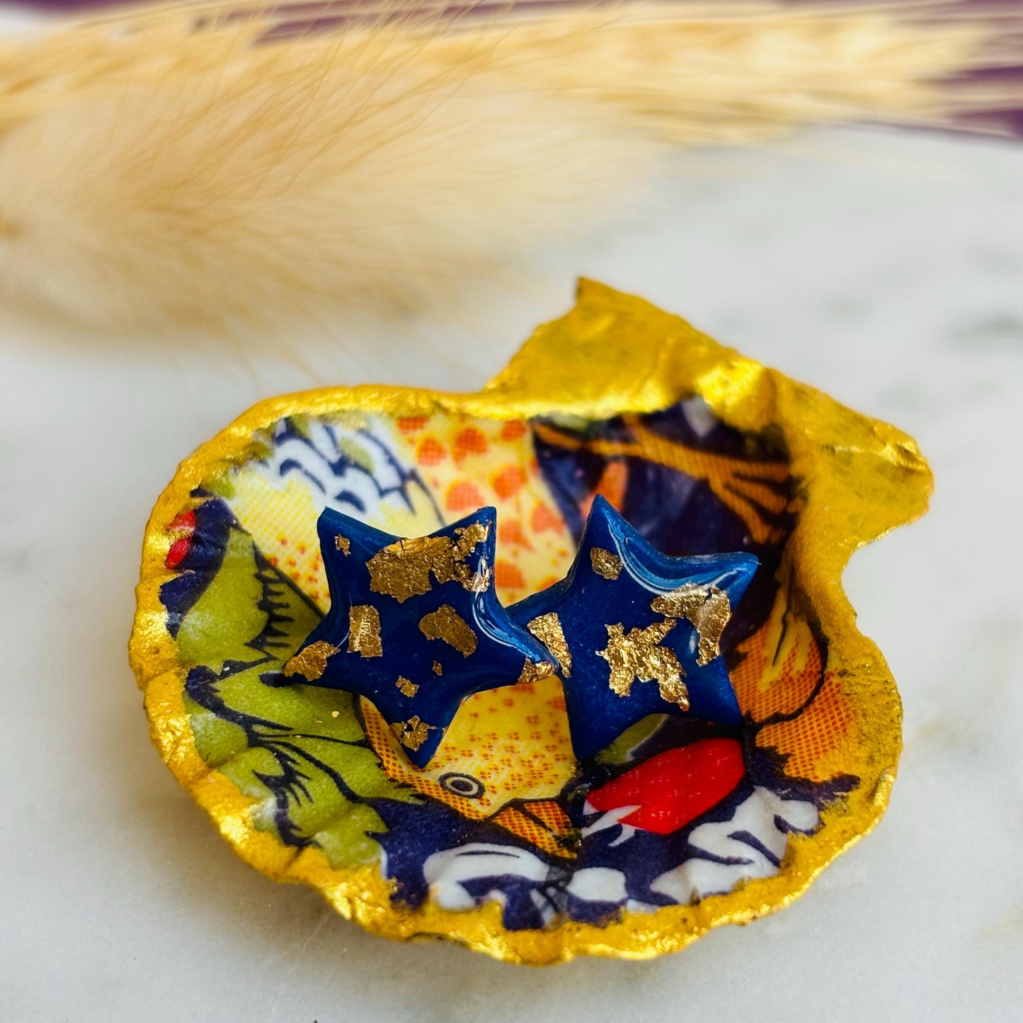 Chic navy blue star-shaped stud earrings with gold foil detailing, handmade with polymer clay.
