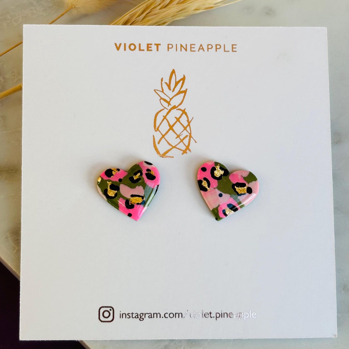 Elegant heart-shaped stud earrings with a hand painted leopard print, handmade with polymer clay