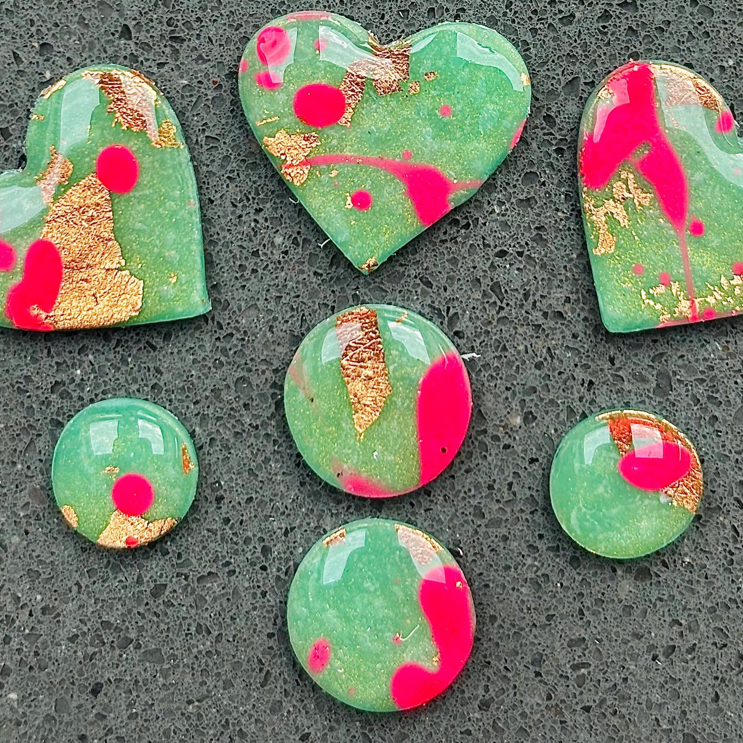 Vibrant neon pink heart-shaped stud earrings, handmade with polymer clay. Features an abstract design with gold foil accents.