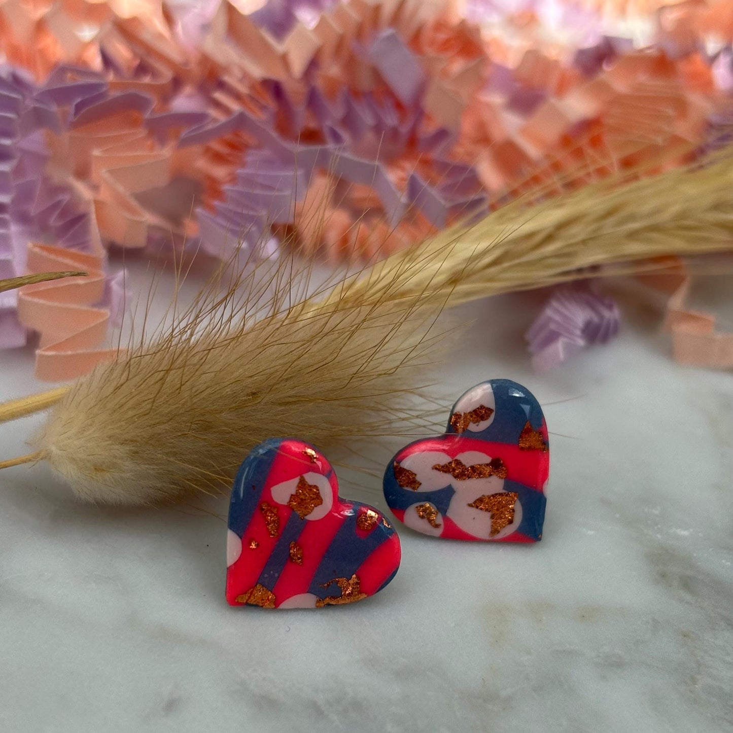 Blue, pink, and rose gold heart stud earrings in a retro 90s style.