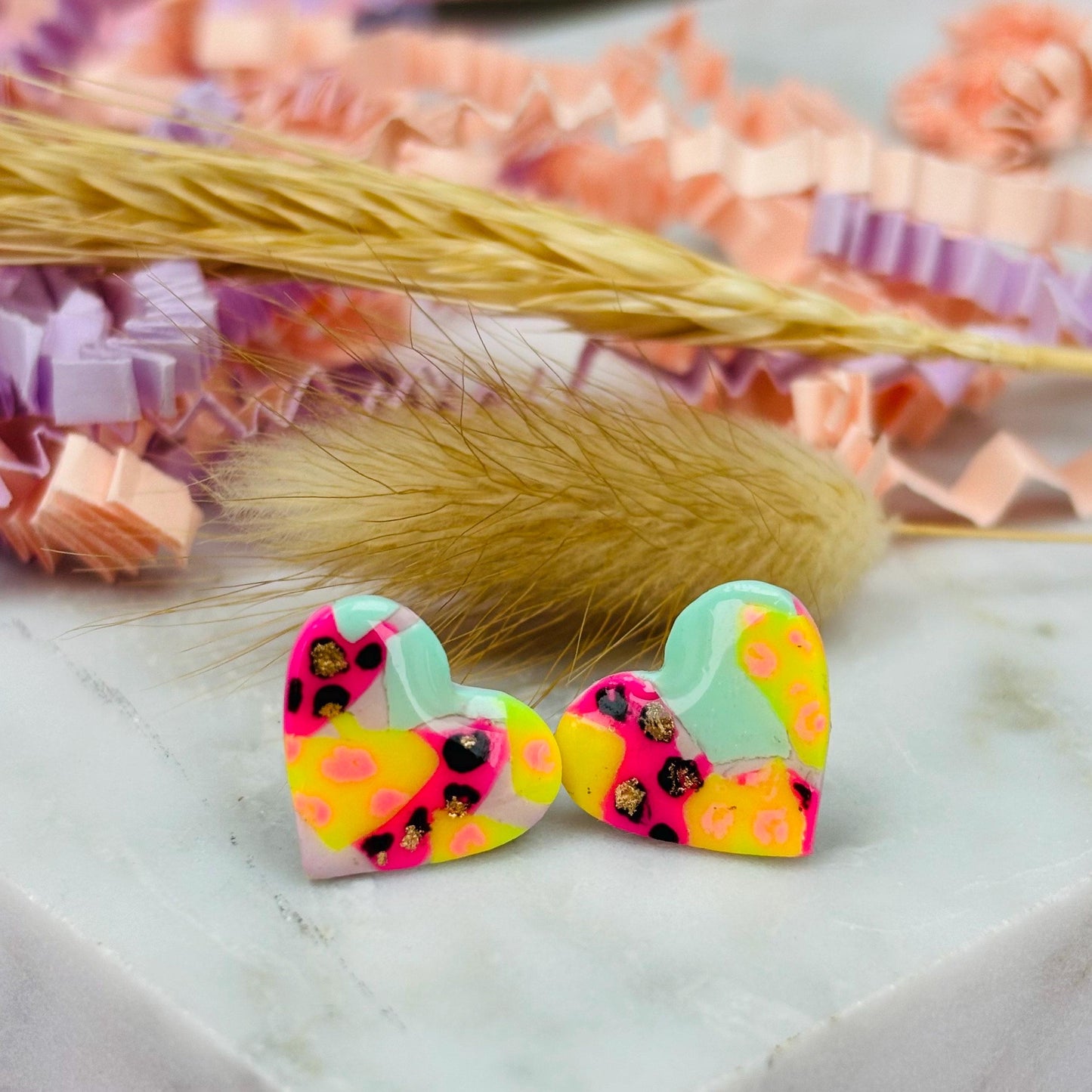 Chic heart-shaped stud earrings with a hand painted leopard print, handmade with polymer clay.