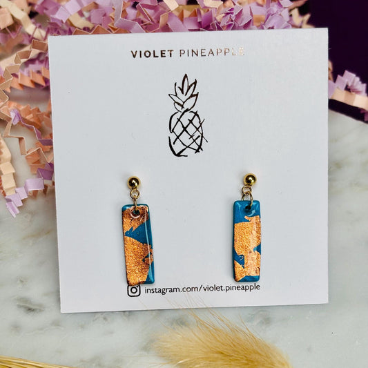 Elegant teal drop earrings with rose gold foil accents, handmade with polymer clay.