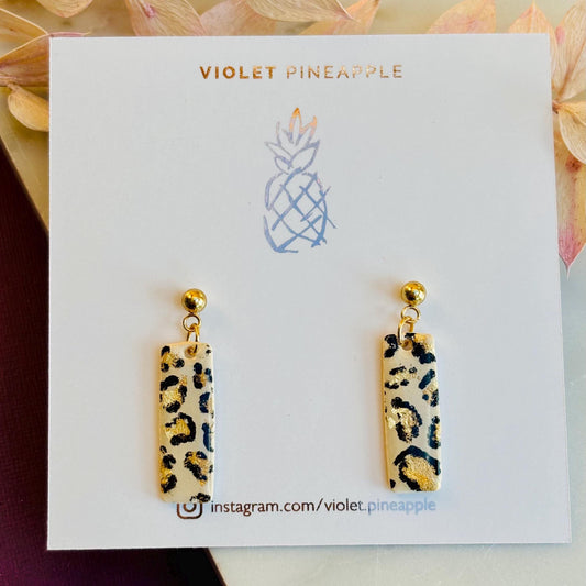 Elegant leopard print drop stud earrings with neutral tones and gold accents, hand-painted and handmade with polymer clay.