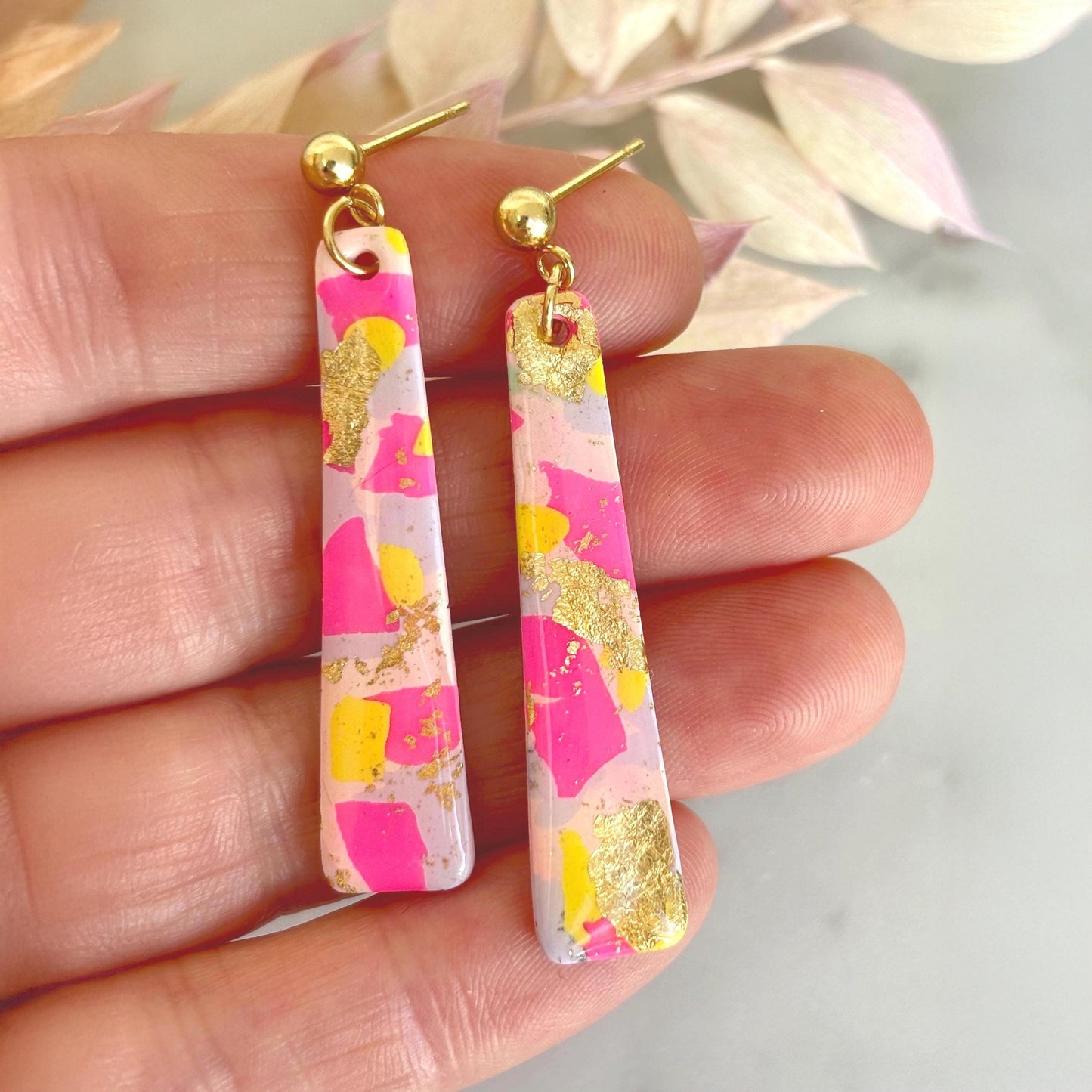 Delicate pastel drop stud earrings with soft pink, blue, and yellow hues and shimmering gold foil detailing, handcrafted from polymer clay.