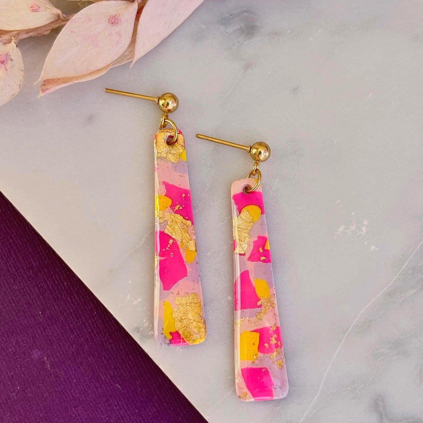 Delicate pastel drop stud earrings with soft pink, blue, and yellow hues and shimmering gold foil detailing, handcrafted from polymer clay.
