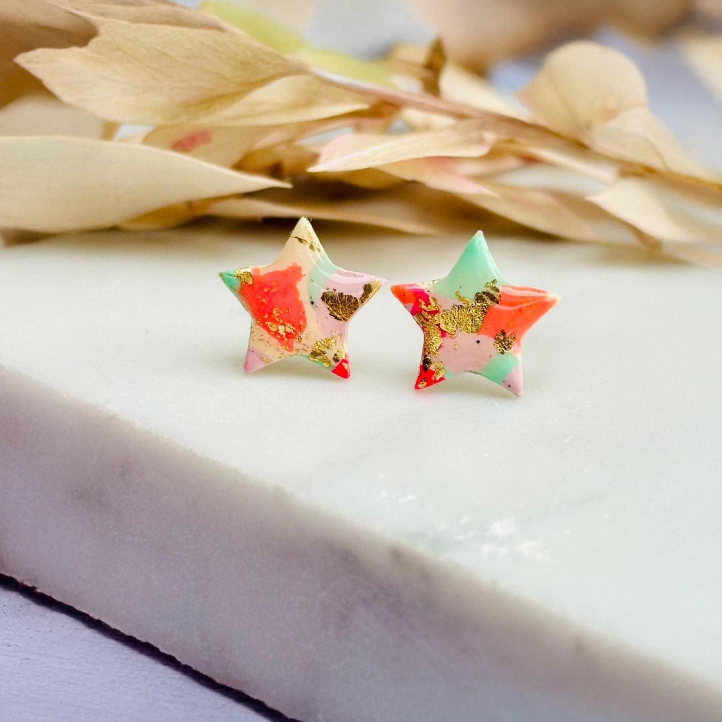 Colourful surf-inspired star stud earrings made from pink, mint, peach polymer clay with gold foil, featuring surgical steel posts and push backs.