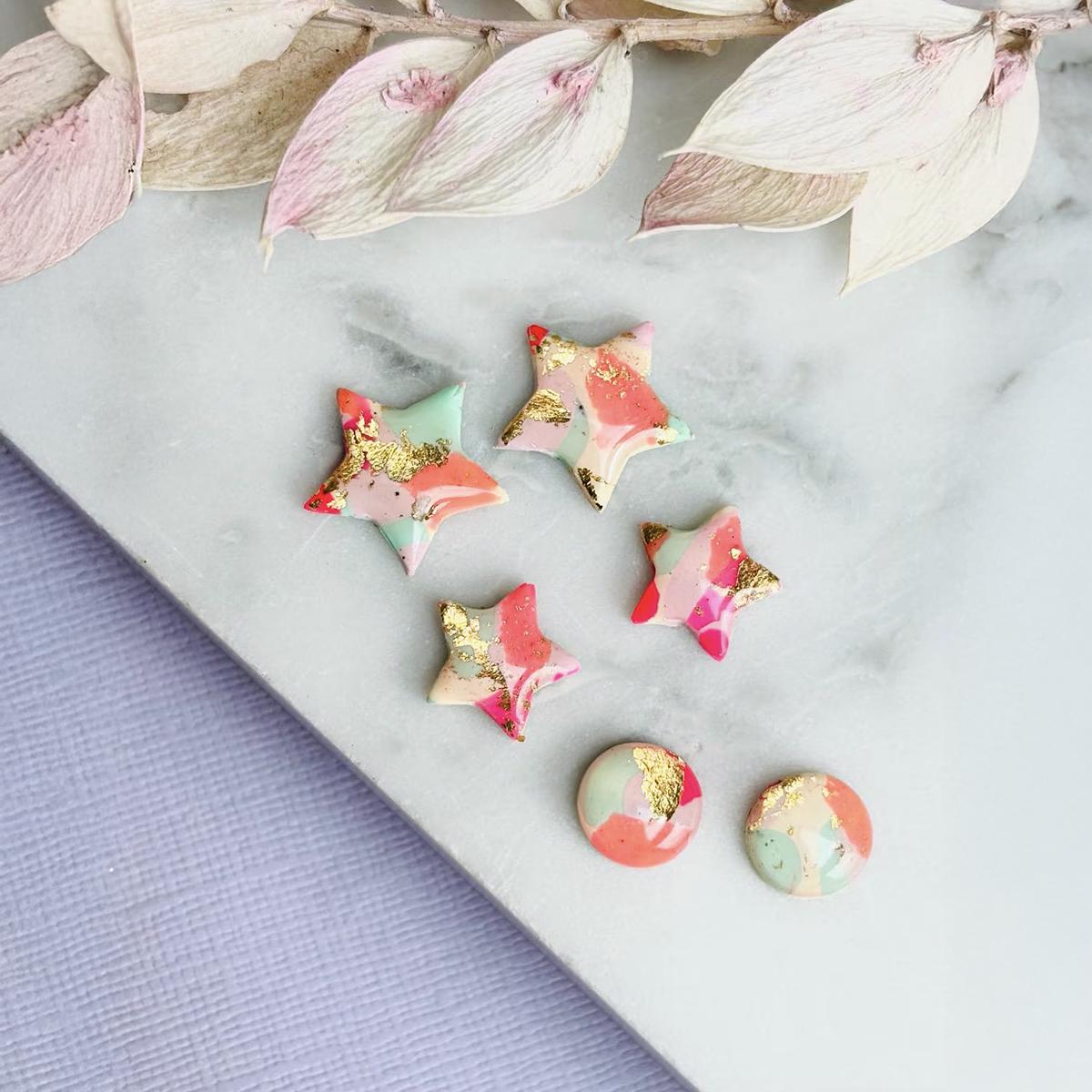Colourful surf-inspired star stud earrings made from pink, mint, peach polymer clay with gold foil, featuring surgical steel posts and push backs.