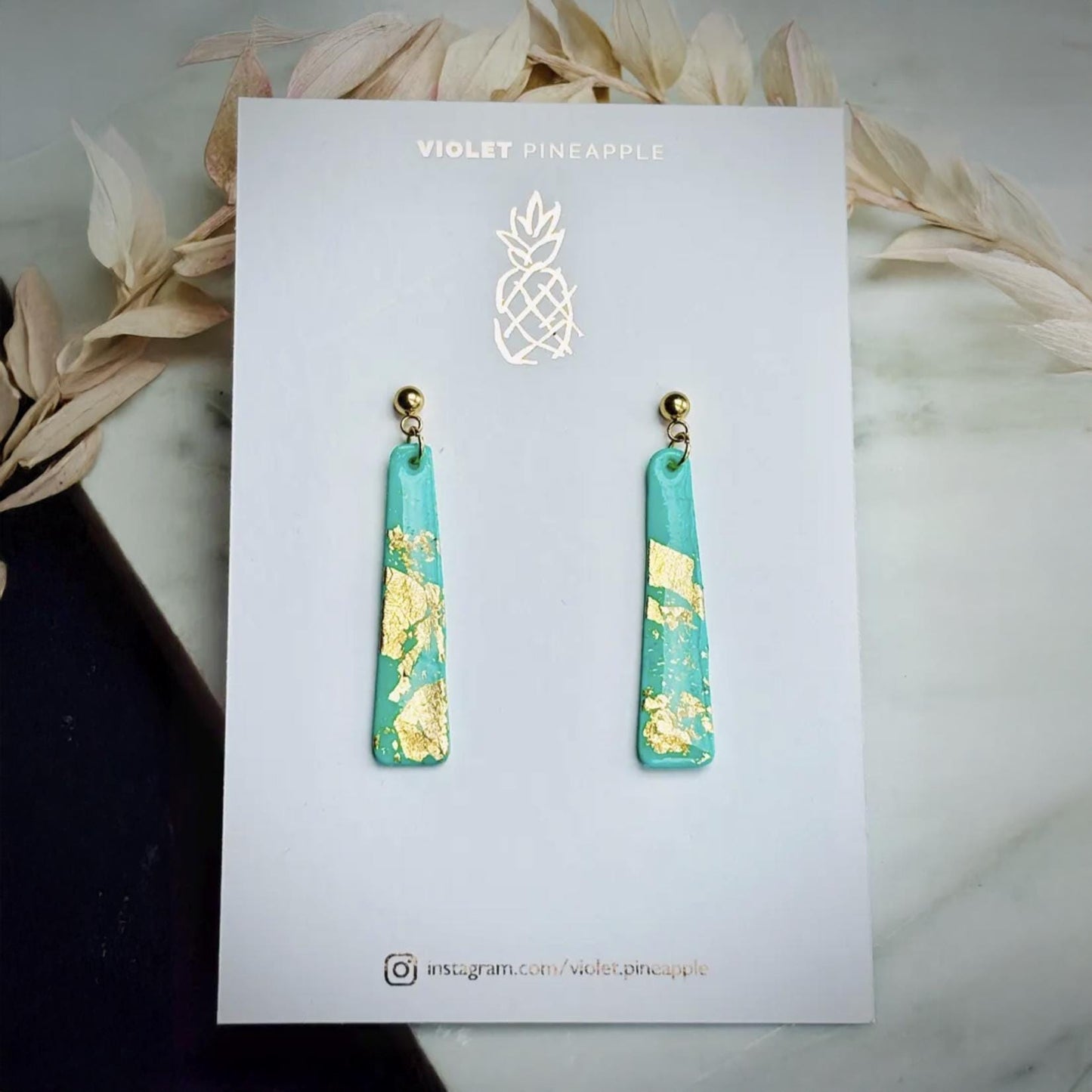 Delicate handmade drop earrings in a soft teal colour with shimmering gold foil accents