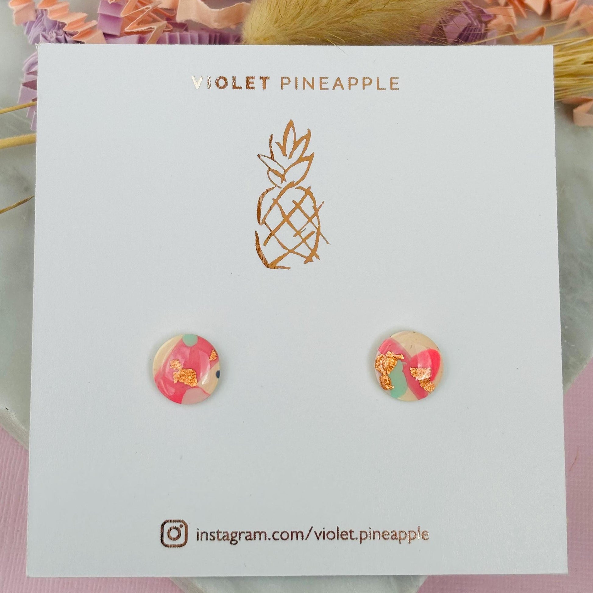 Handmade blush pink stud earrings with soft mint pastel undertones and delicate rose gold leaf detail. Finished with a glossy resin for durability and a refined look.