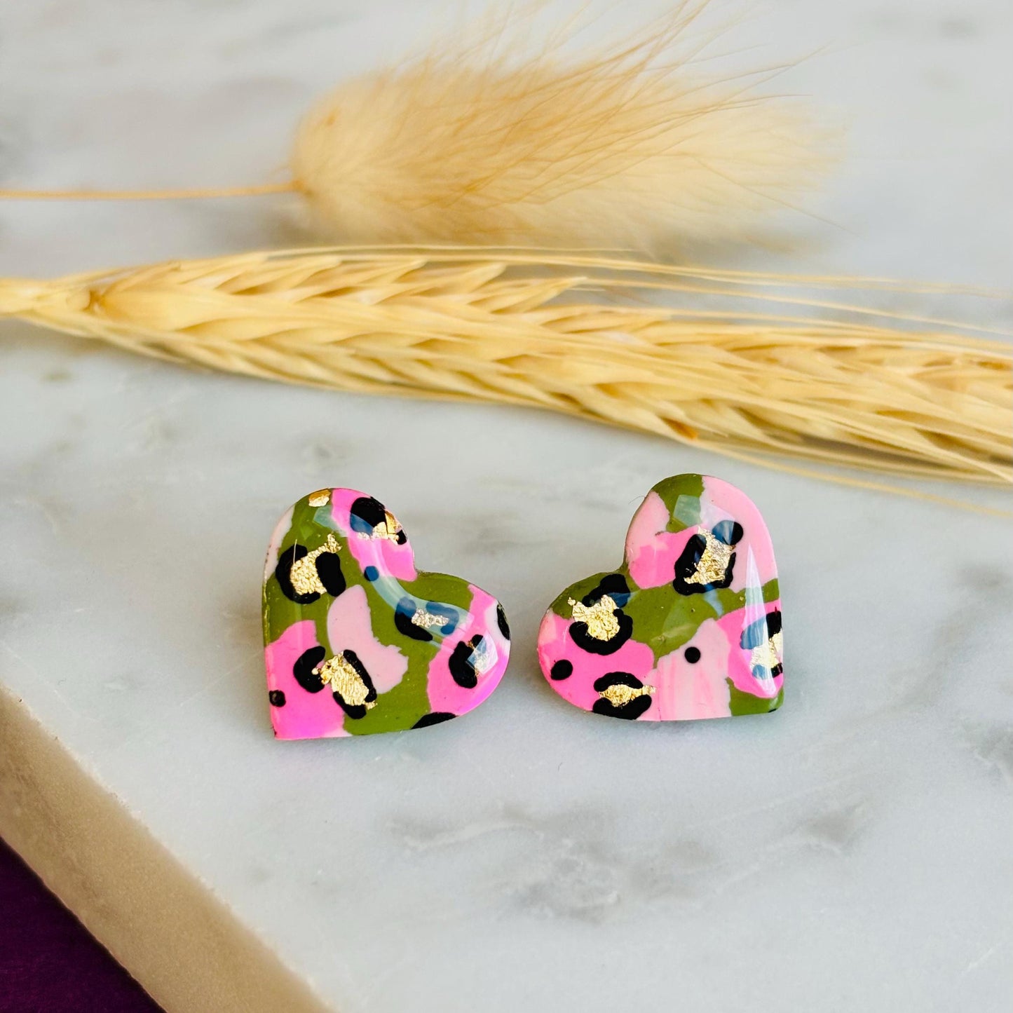 Elegant heart-shaped stud earrings with a hand painted leopard print, handmade with polymer clay