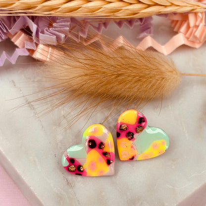 Chic heart-shaped stud earrings with a hand painted leopard print, handmade with polymer clay.
