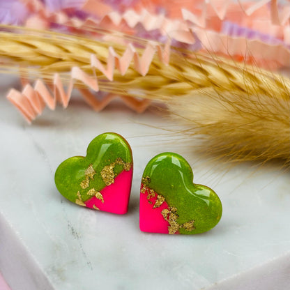 Tropical watermelon-inspired heart-shaped stud earrings, handmade with polymer clay. Features emerald green and neon pink with gold foil accents.