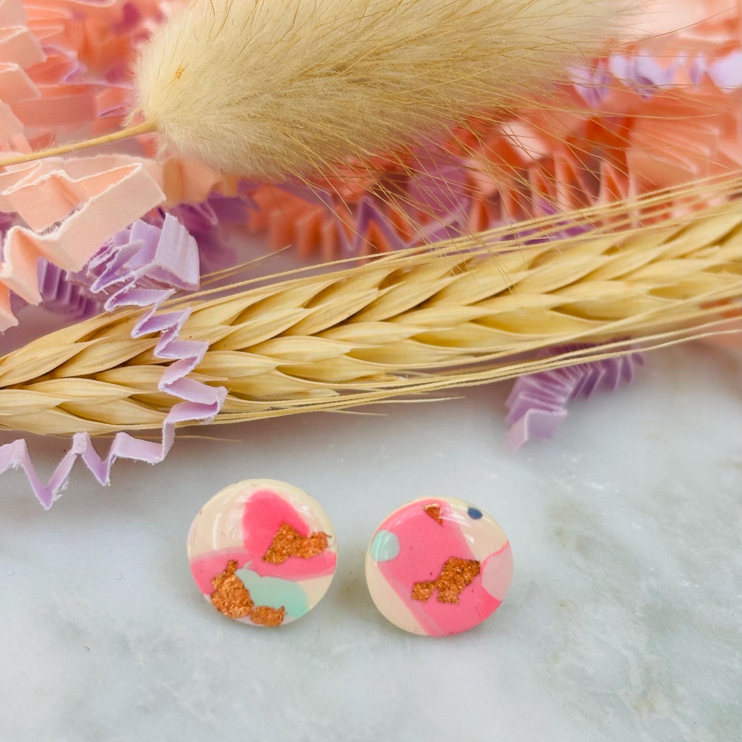 Handmade blush pink stud earrings with soft mint pastel undertones and delicate rose gold leaf detail. Finished with a glossy resin for durability and a refined look.