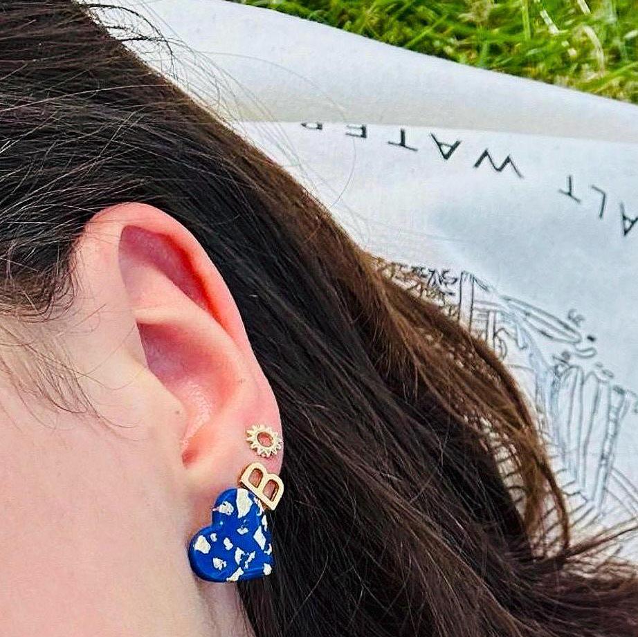 Chic navy blue star-shaped stud earrings with gold foil detailing, handmade with polymer clay.