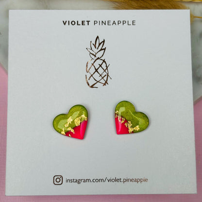Tropical watermelon-inspired heart-shaped stud earrings, handmade with polymer clay. Features emerald green and neon pink with gold foil accents.
