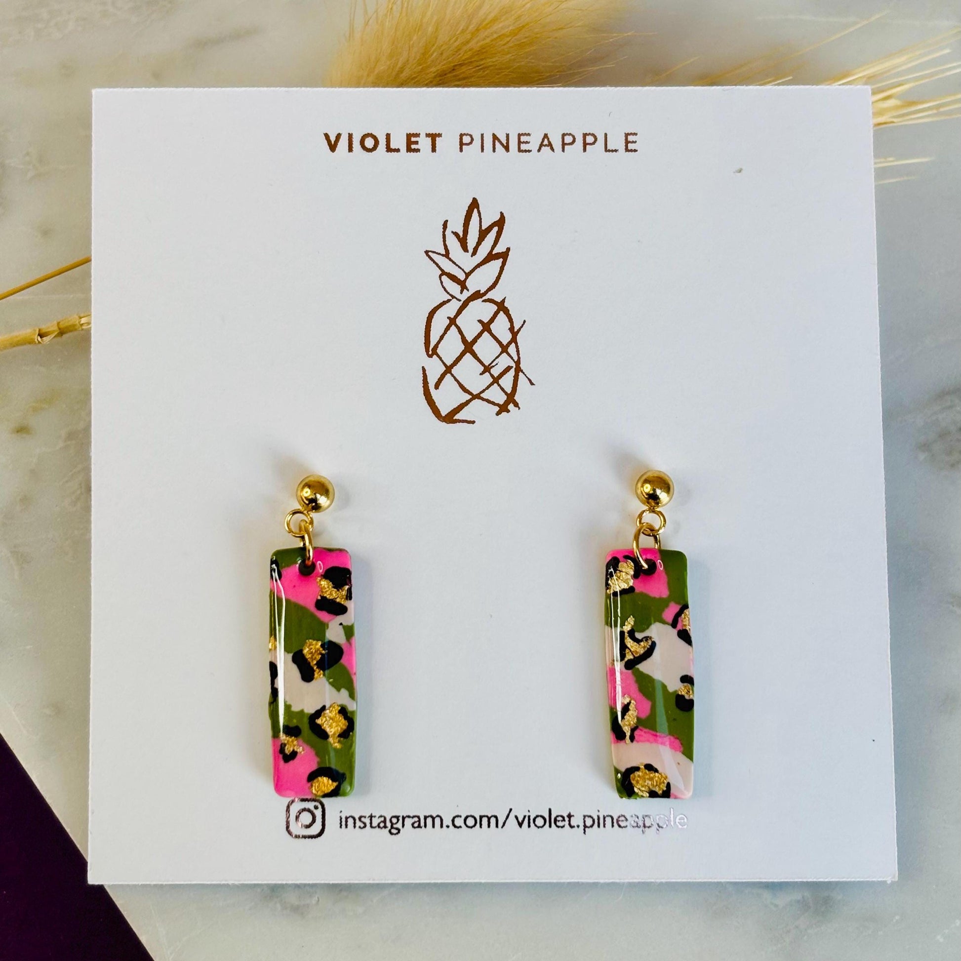 Elegant leopard print drop earrings with gold foil accents, handmade with polymer clay.