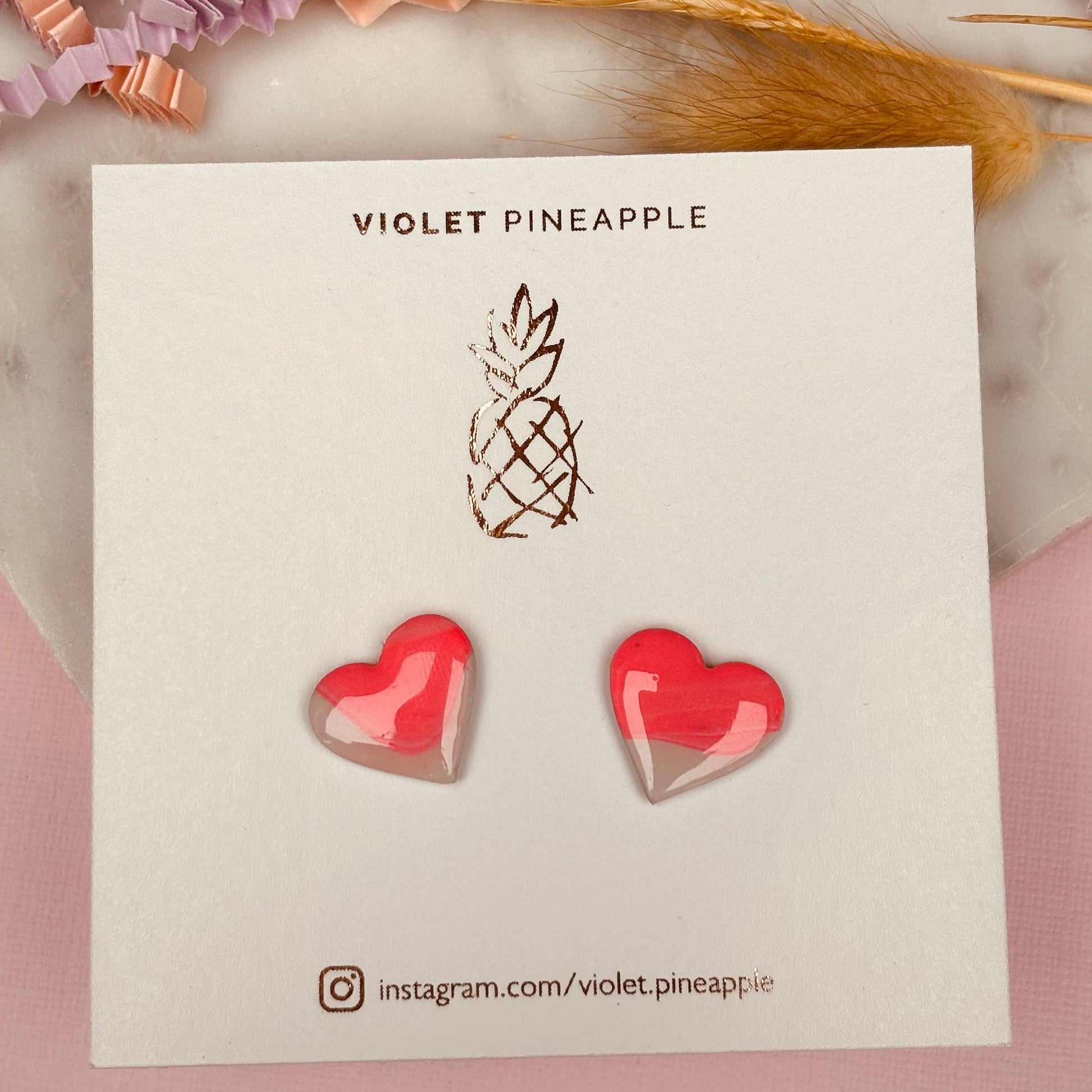 Delicate pink heart-shaped stud earrings, handmade with polymer clay.