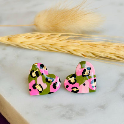 Elegant heart-shaped stud earrings with a hand painted leopard print, handmade with polymer clay.