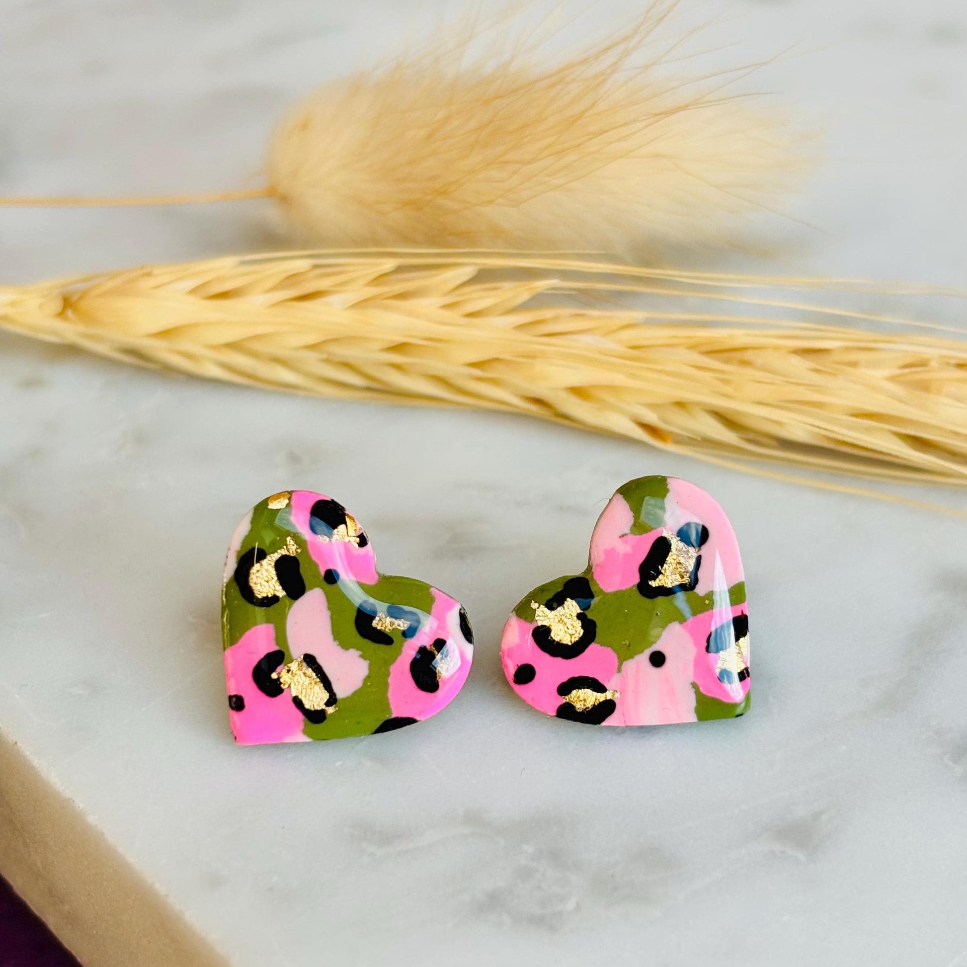 Elegant heart-shaped stud earrings with a hand painted leopard print, handmade with polymer clay