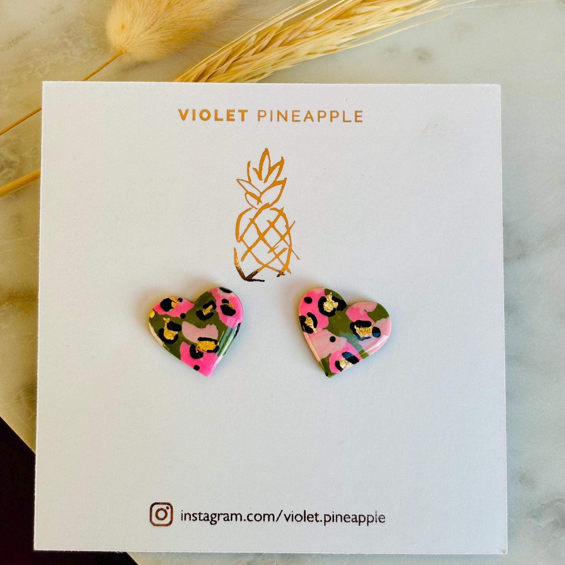 Elegant heart-shaped stud earrings with a hand painted leopard print, handmade with polymer clay