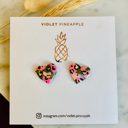 Elegant heart-shaped stud earrings with a hand painted leopard print, handmade with polymer clay.