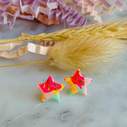 Vibrant 90s-inspired star-shaped stud earrings, handmade with polymer clay. Features a bold leopard print pattern and a mix of vibrant colours.
