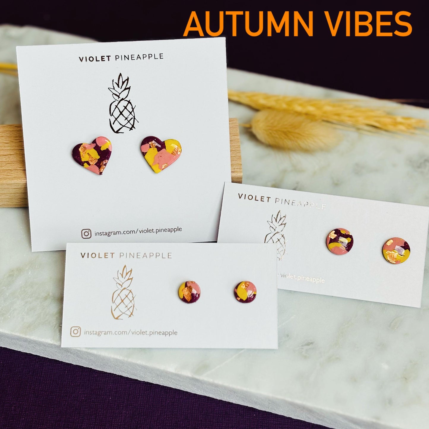 Mini stud earrings with a warm color palette of plum, blush pink, and ochre yellow with gold foil accents, handmade with polymer clay.
