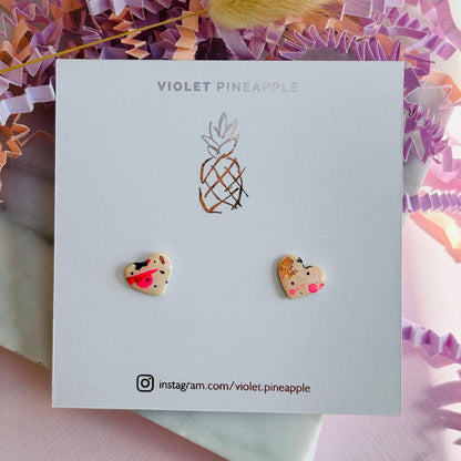 Quirky 90s-inspired neon pink heart-shaped stud earrings, handmade with polymer clay.