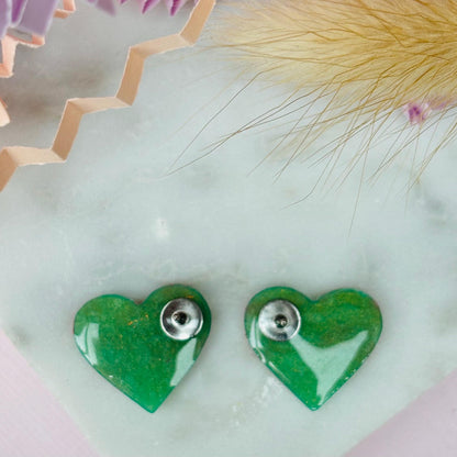 Vibrant neon pink heart-shaped stud earrings, handmade with polymer clay. Features an abstract design with gold foil accents.