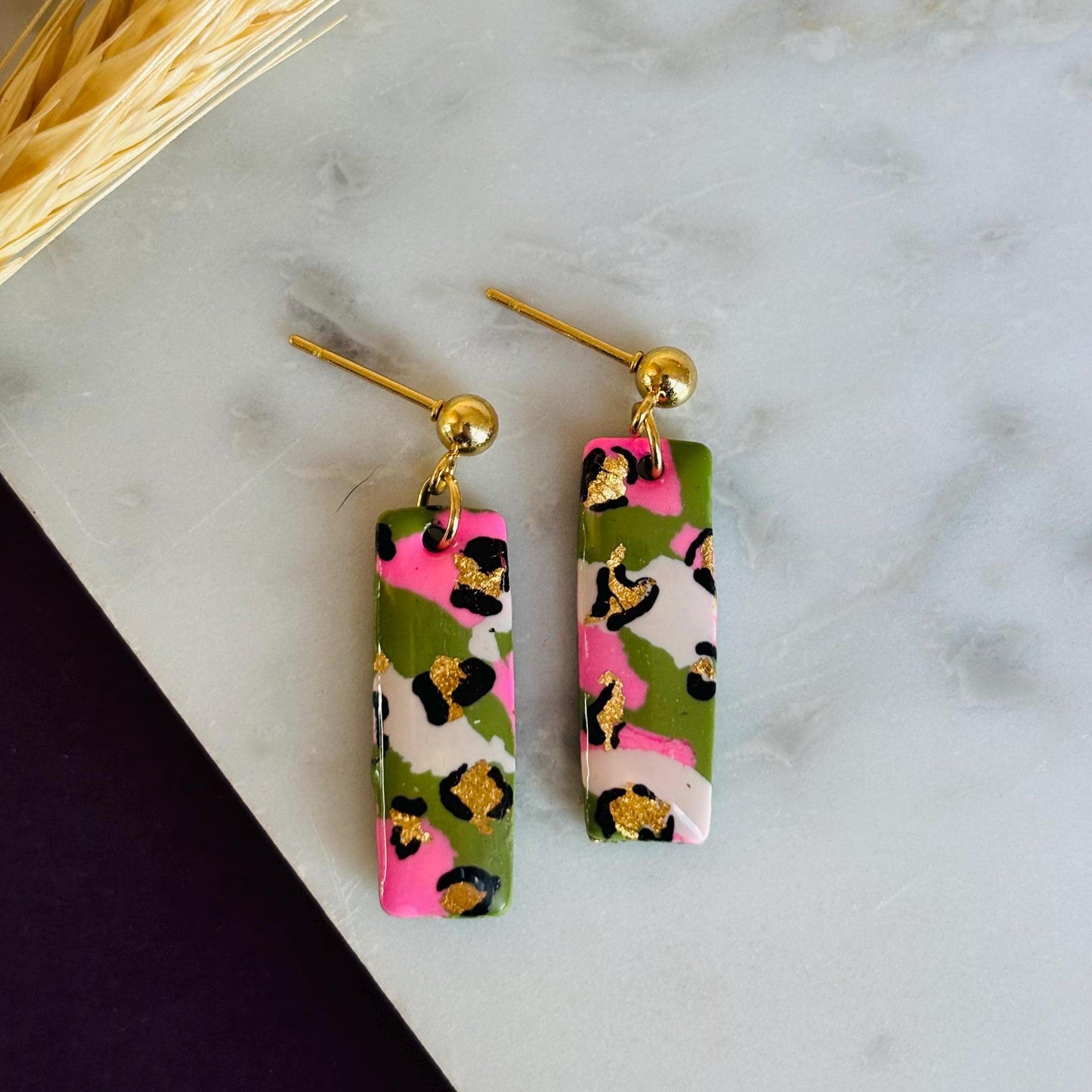 Elegant leopard print drop earrings with gold foil accents, handmade with polymer clay.