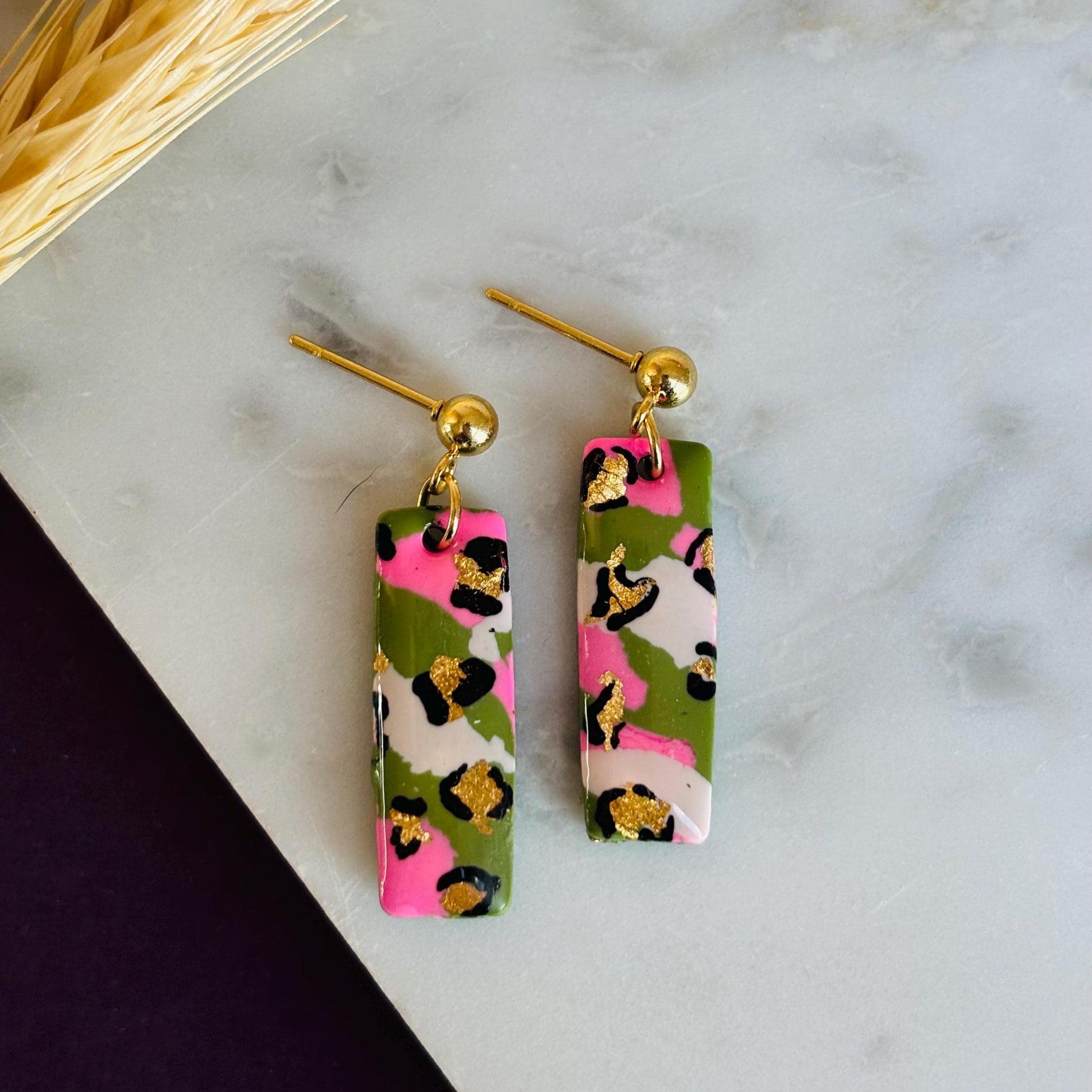 Elegant leopard print drop earrings with gold foil accents, handmade with polymer clay.