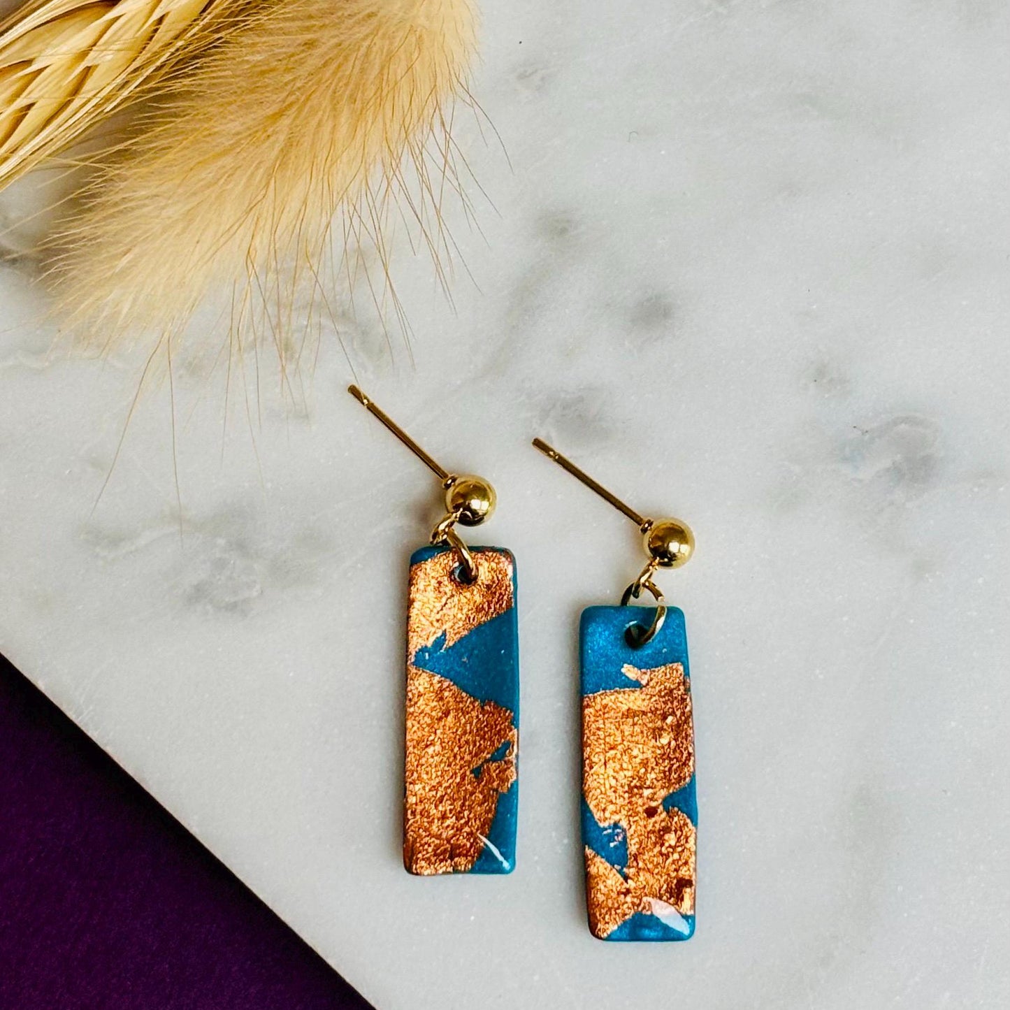 Elegant teal drop earrings with rose gold foil accents, handmade with polymer clay.