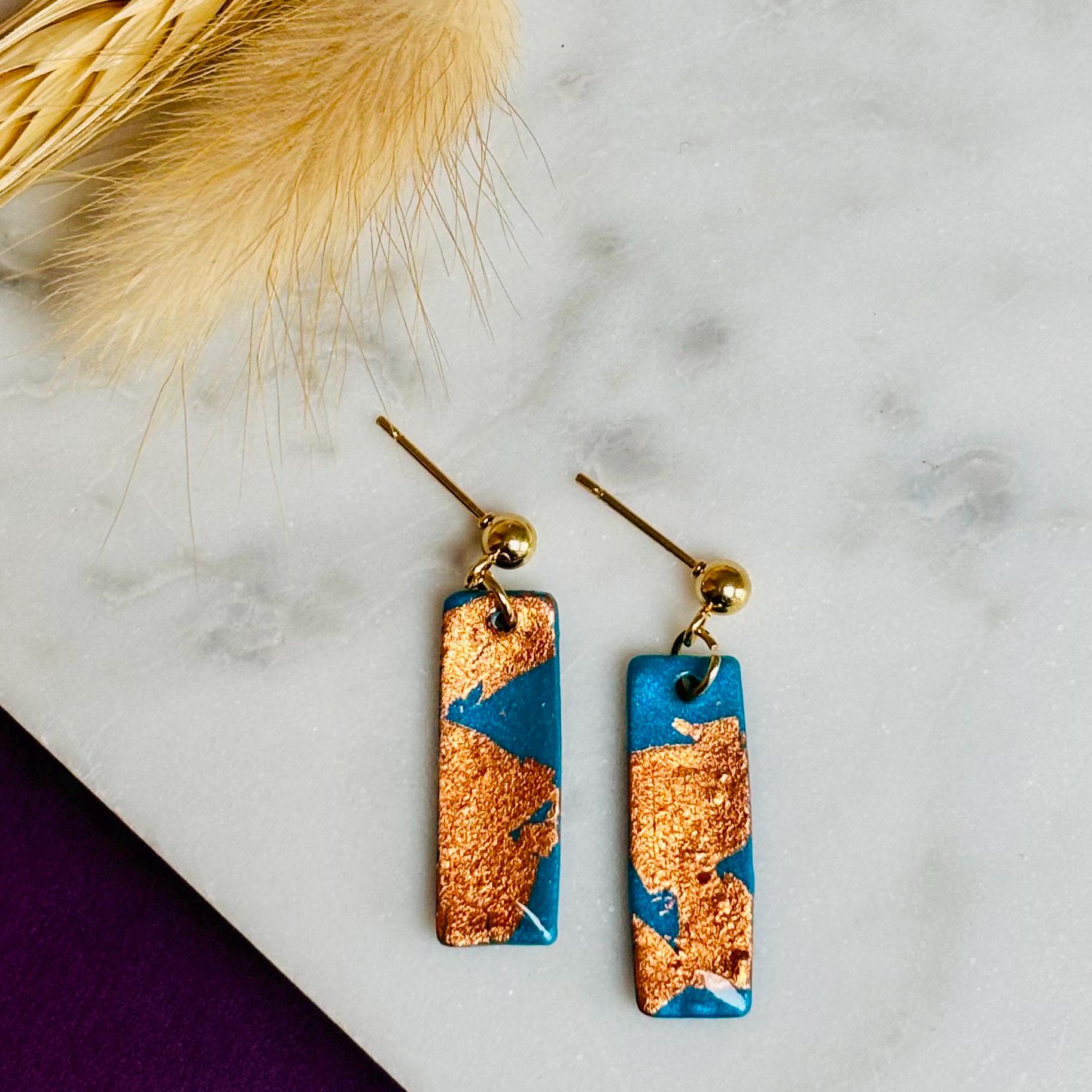 Elegant teal drop earrings with rose gold foil accents, handmade with polymer clay.