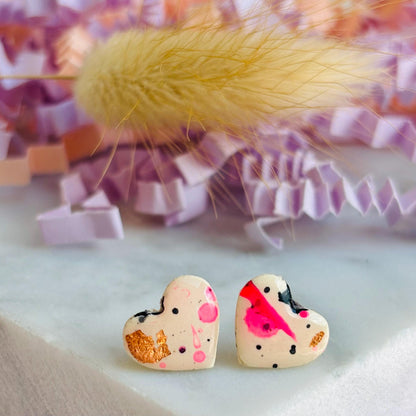 Quirky 90s-inspired neon pink heart-shaped stud earrings, handmade with polymer clay.