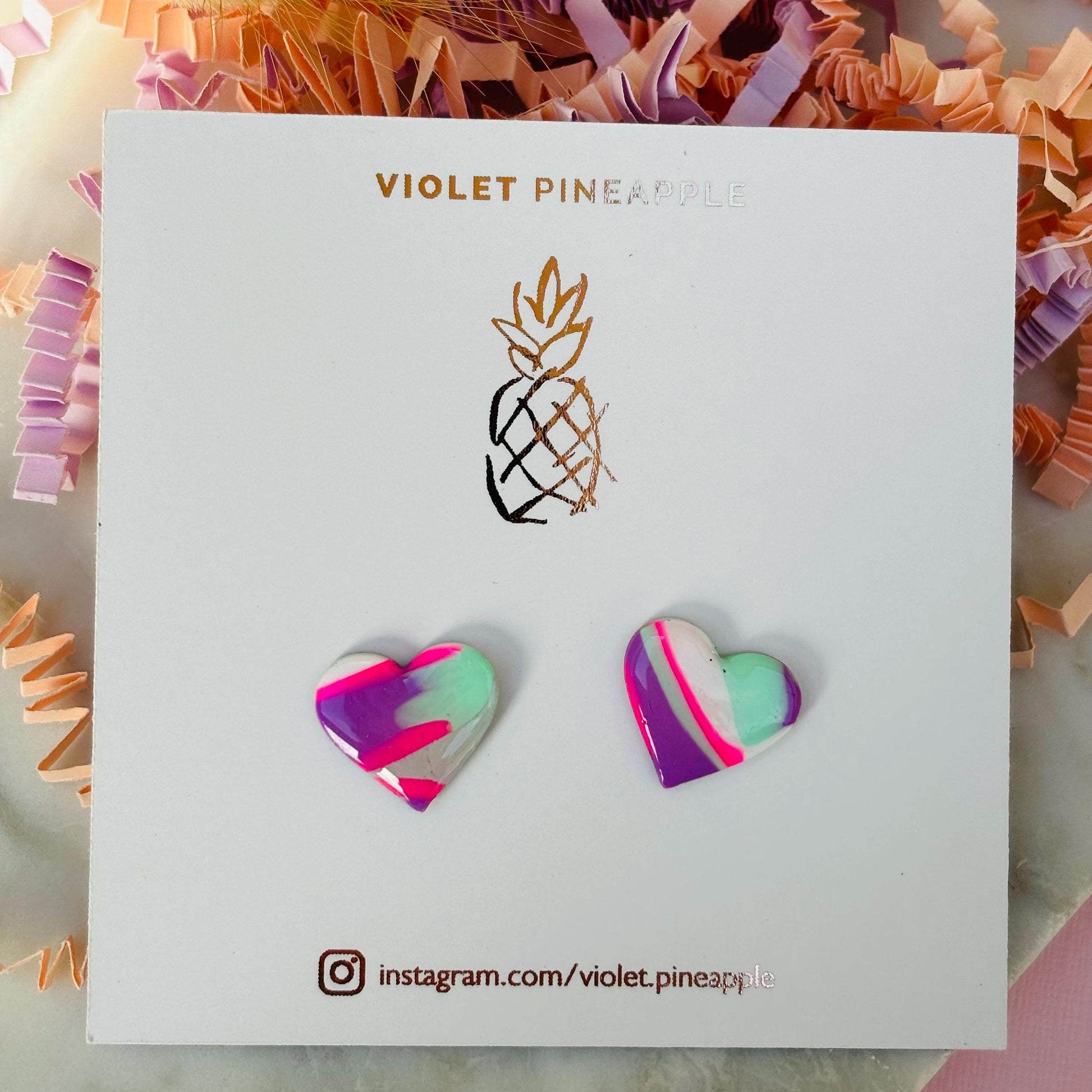 Vibrant 80s-inspired heart-shaped stud earrings, handmade with polymer clay. Features a bold color palette reminiscent of a winter ski slope.