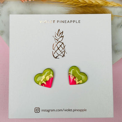 Tropical watermelon-inspired heart-shaped stud earrings, handmade with polymer clay. Features emerald green and neon pink with gold foil accents.