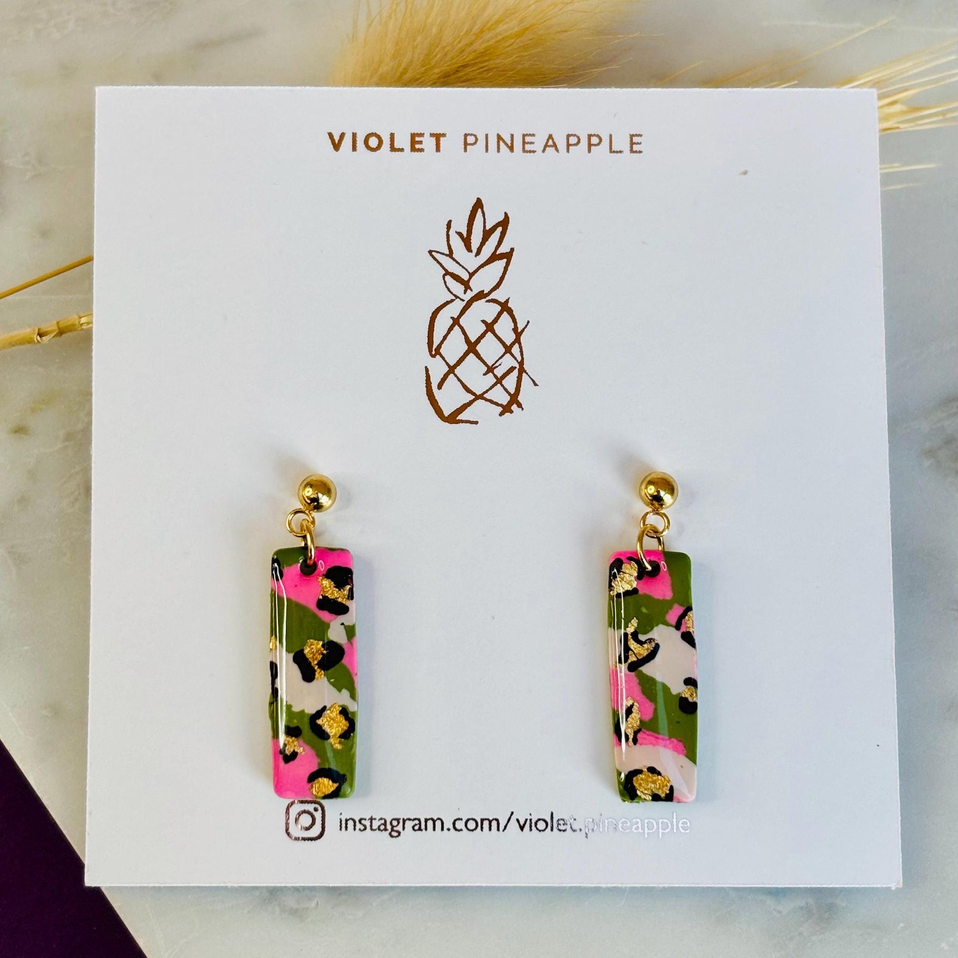 Elegant leopard print drop earrings with gold foil accents, handmade with polymer clay.