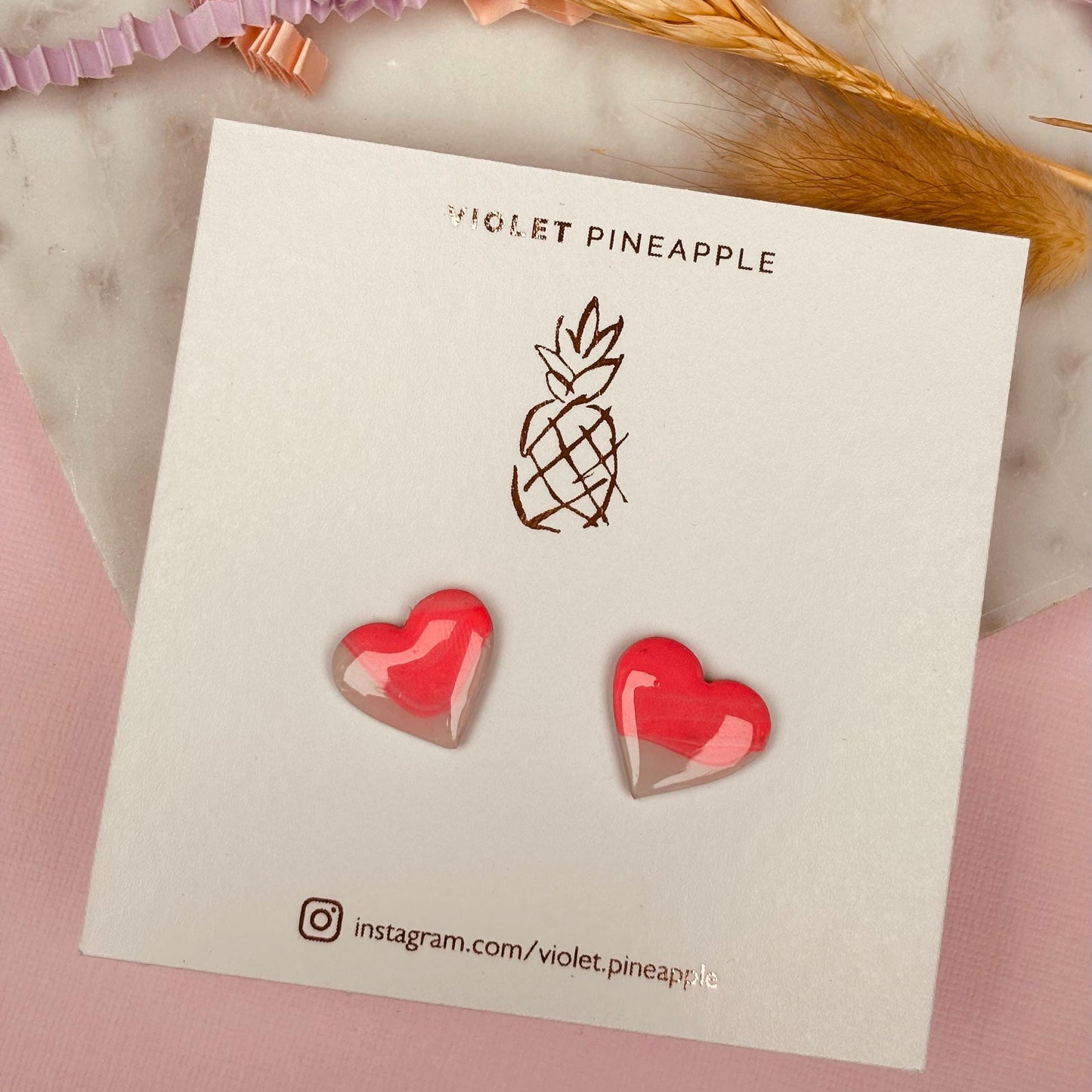 Delicate pink heart-shaped stud earrings, handmade with polymer clay.