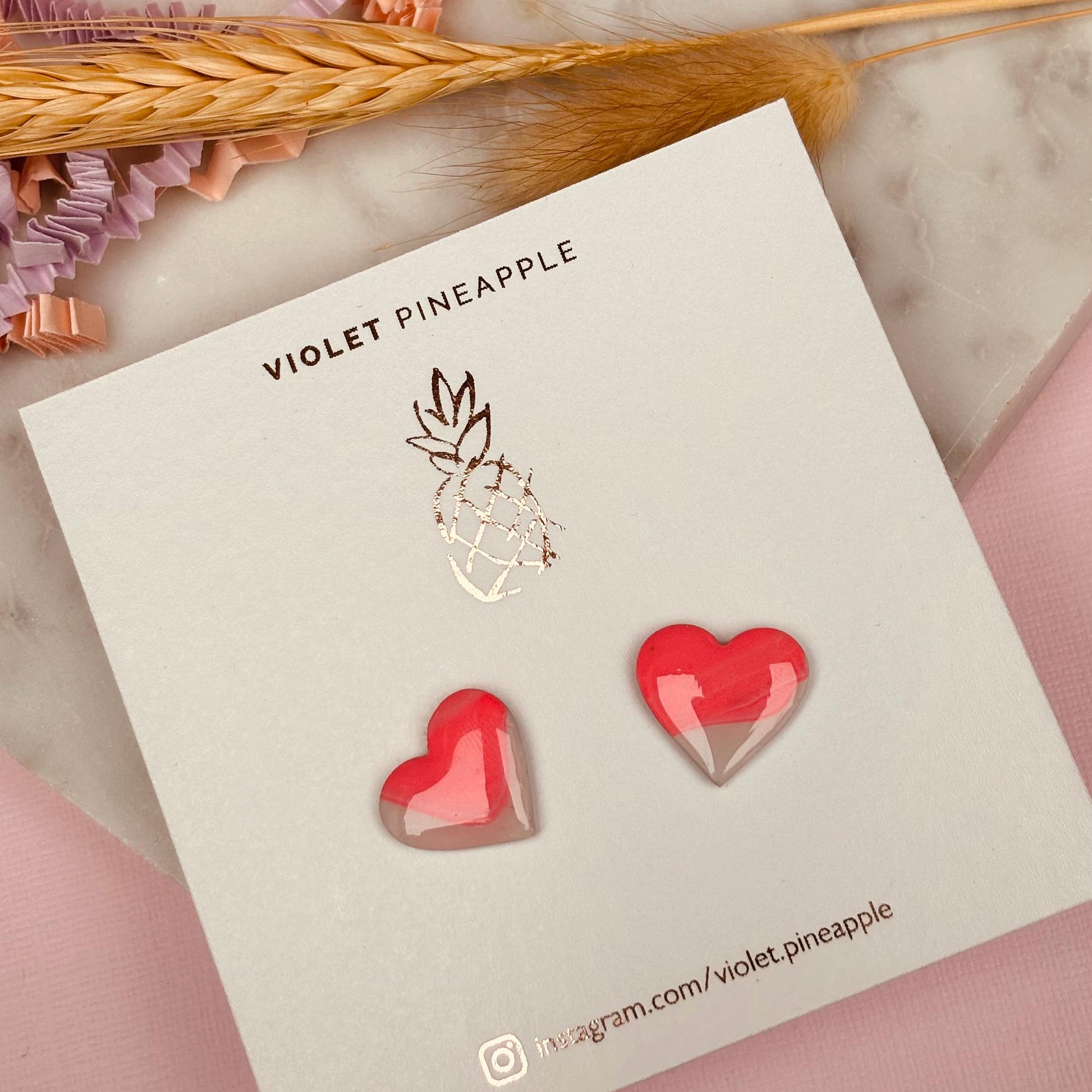 Delicate pink heart-shaped stud earrings, handmade with polymer clay.