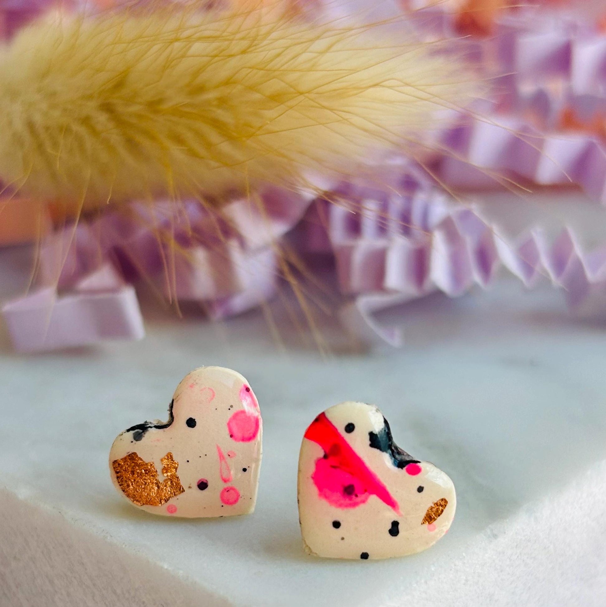 Quirky 90s-inspired neon pink heart-shaped stud earrings, handmade with polymer clay.