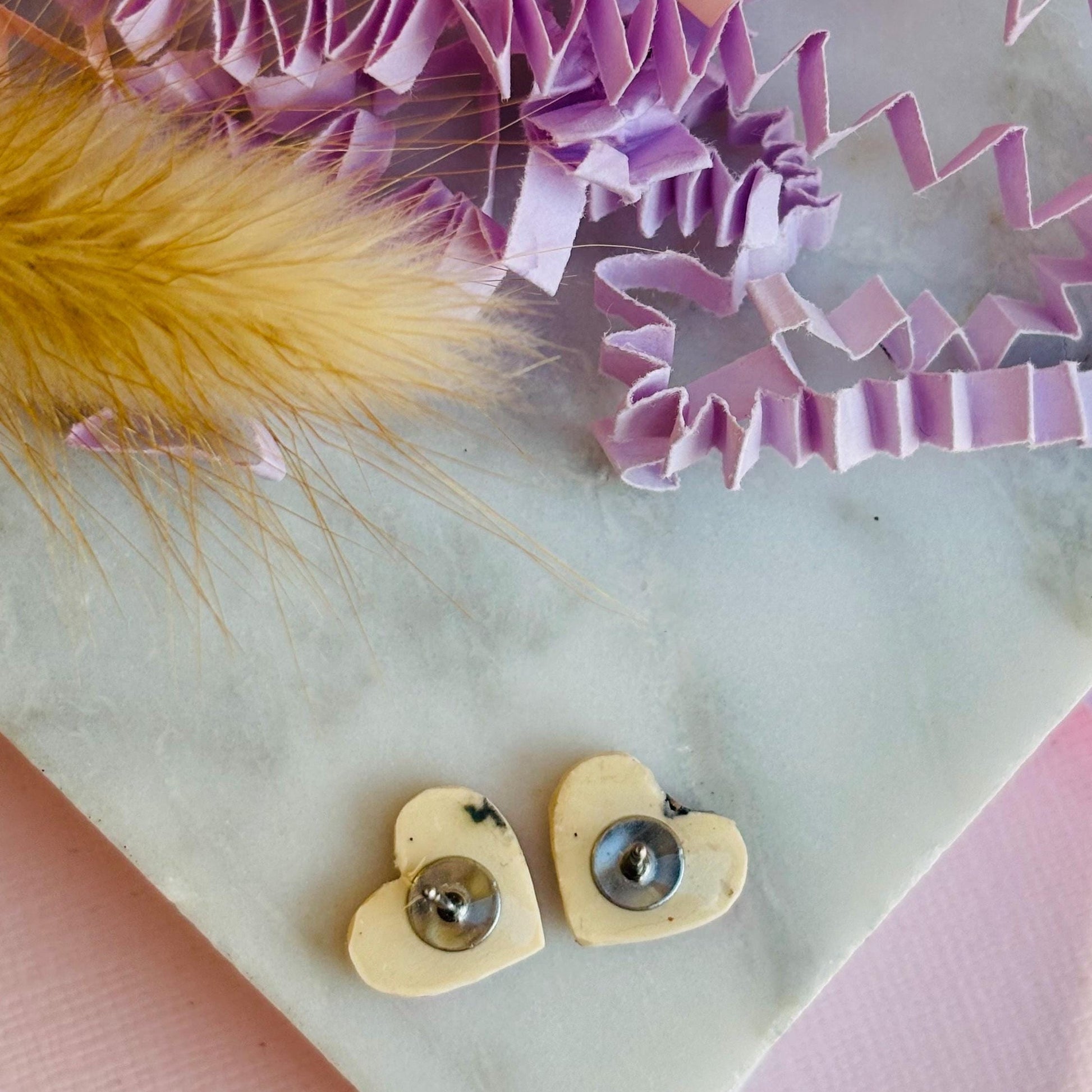 Quirky 90s-inspired neon pink heart-shaped stud earrings, handmade with polymer clay.