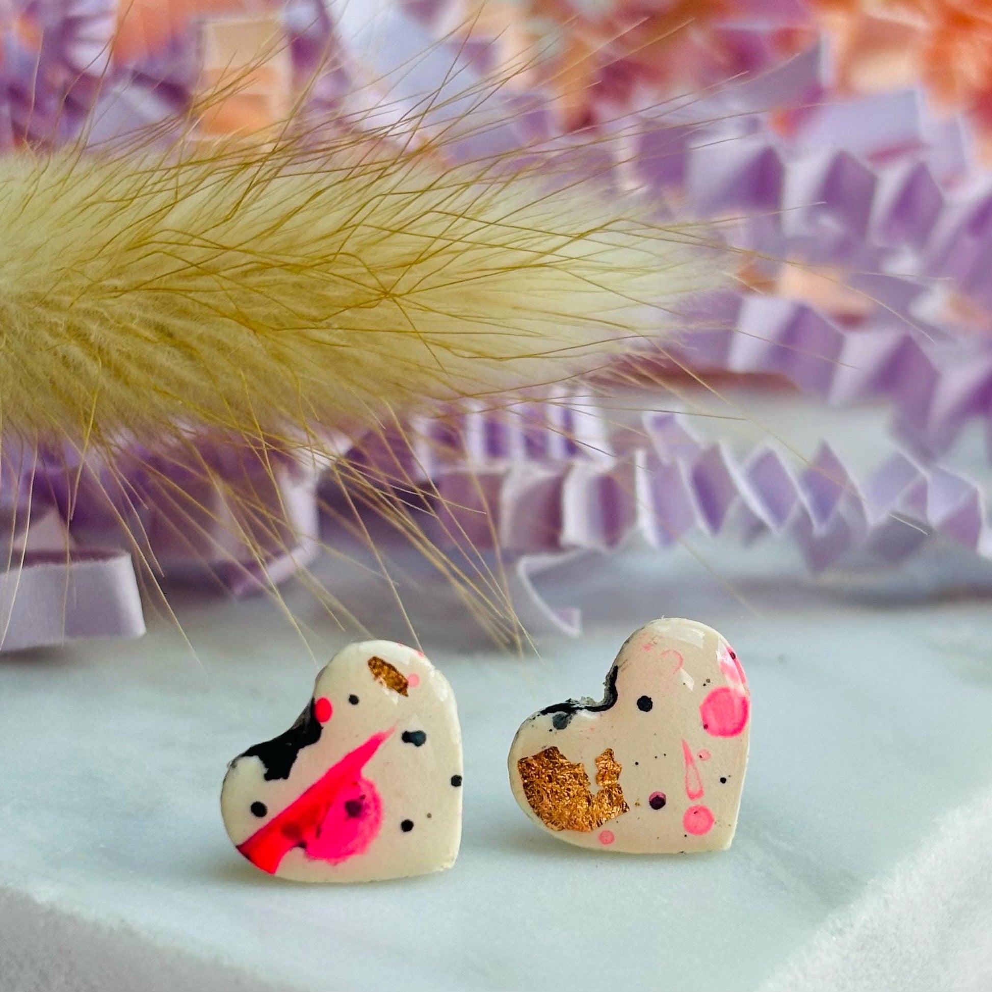 Quirky 90s-inspired neon pink heart-shaped stud earrings, handmade with polymer clay.